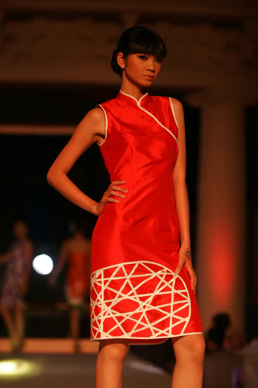 Model in a red hand-painted dress on the runway in Beijing, 2009