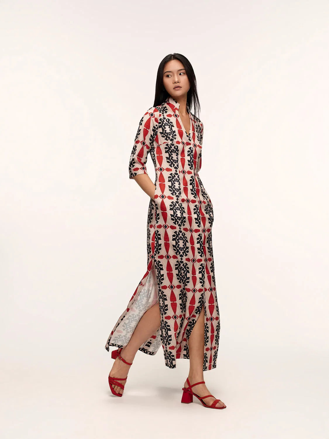 Model in a long hand-painted dress of red and black geometric pattern