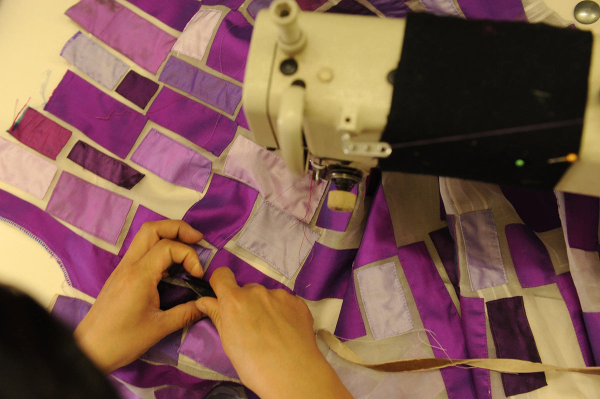 A Chula artisan hand-sewing purple patchwork at the machine, 2006