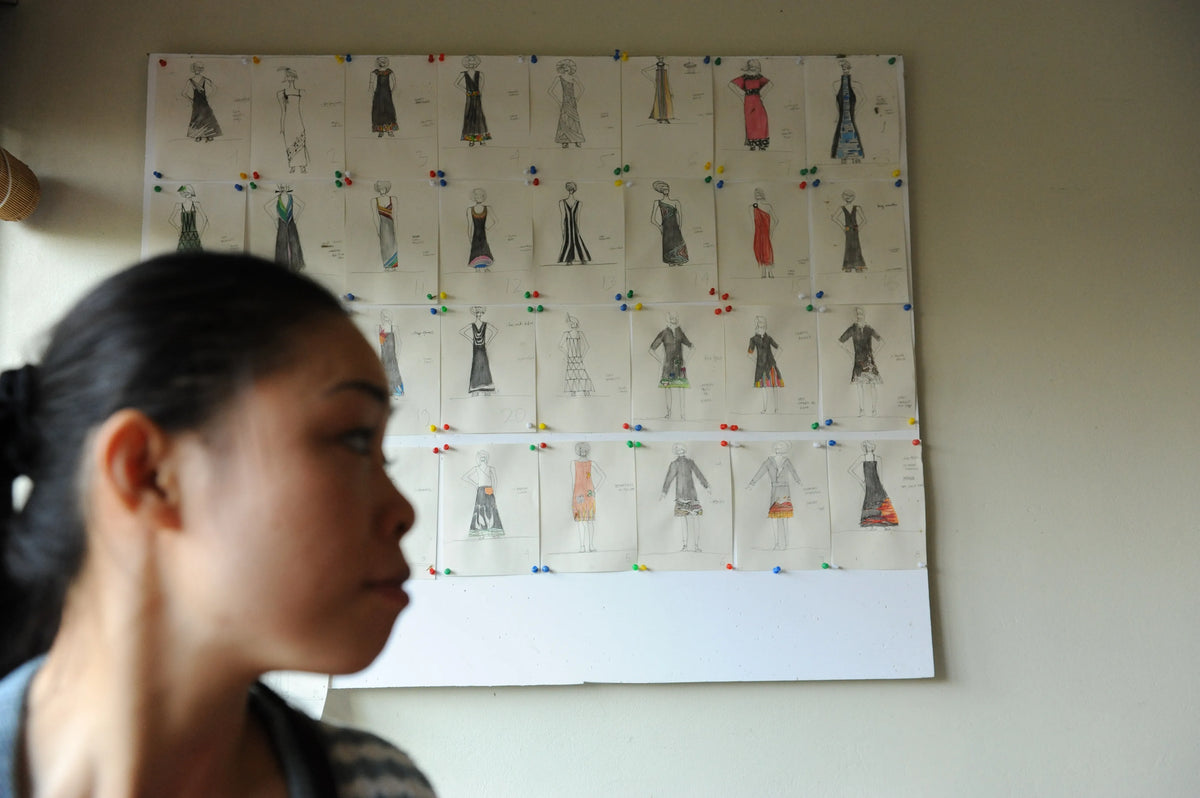 A designer at work before a board of dress sketches, 2006