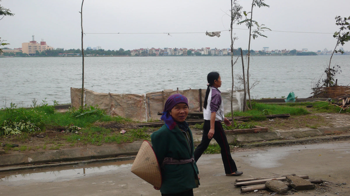 A Vietnamese tailor walking beside West Lake in Hanoi, 2006