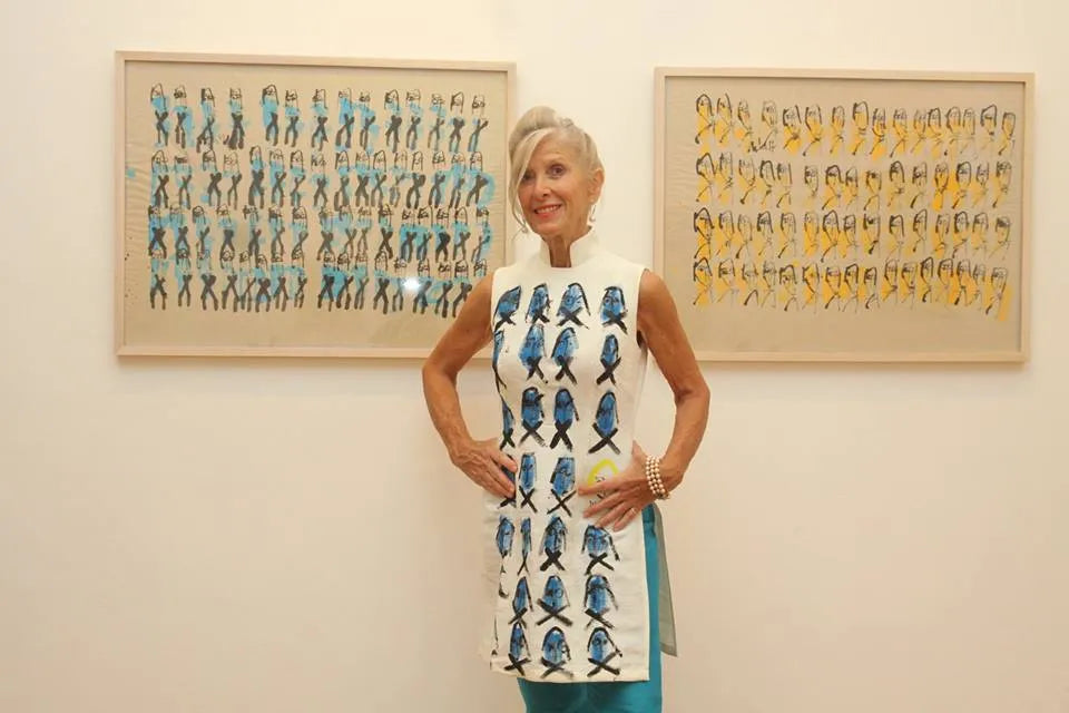 Suzanne Letch in the Chula fish dress between two framed artworks