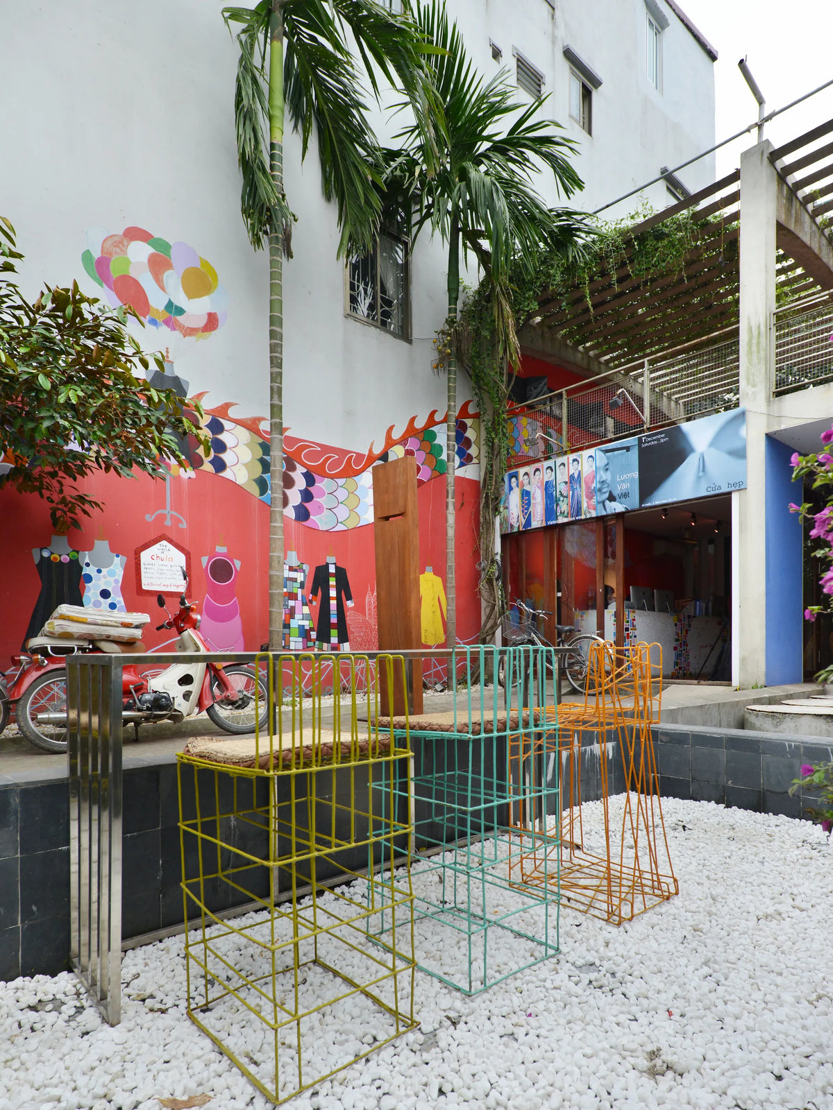 The painted courtyard and wire furniture at the 3 Nhat Chieu house