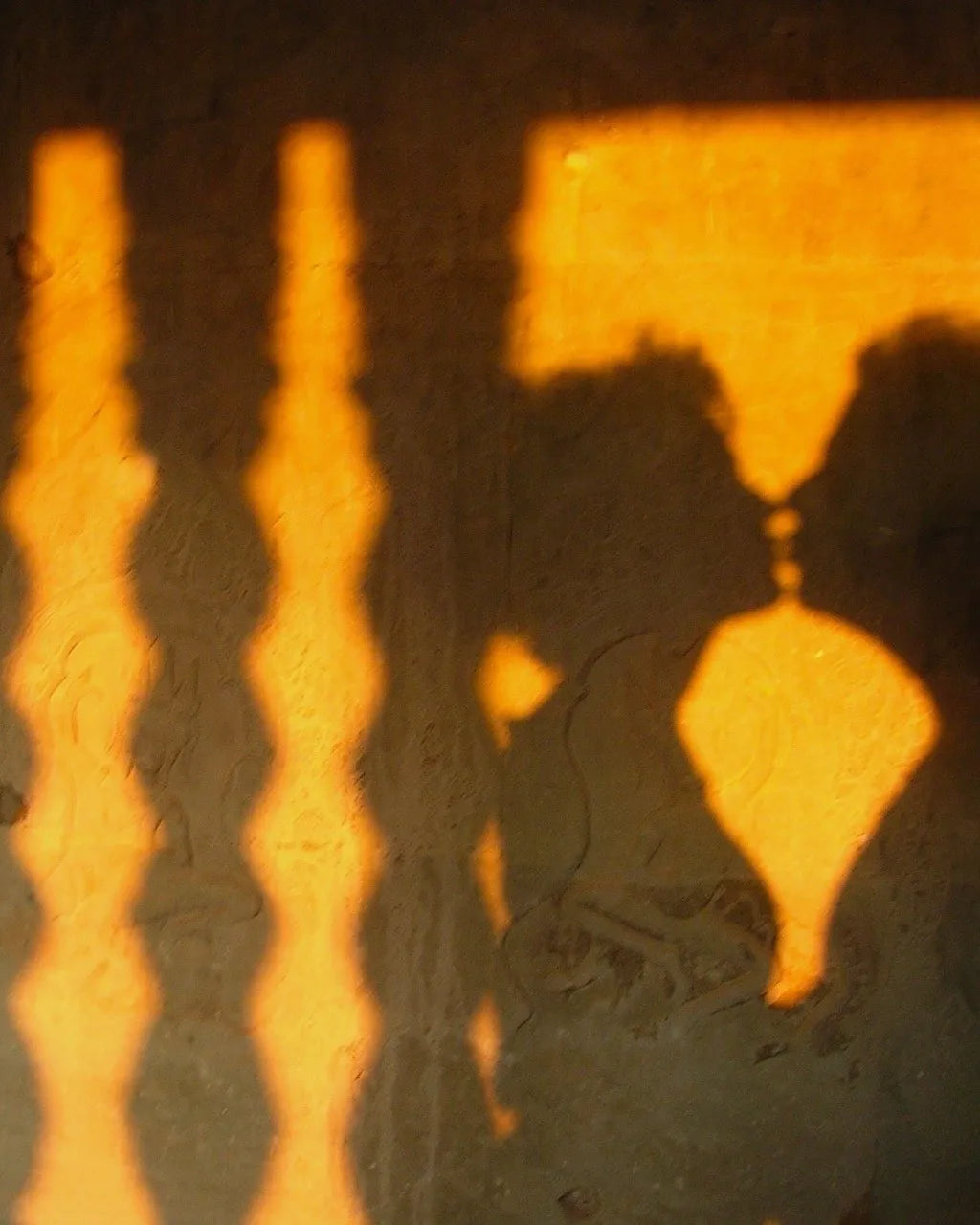 Lamplight thrown across a wall in a Hanoi house