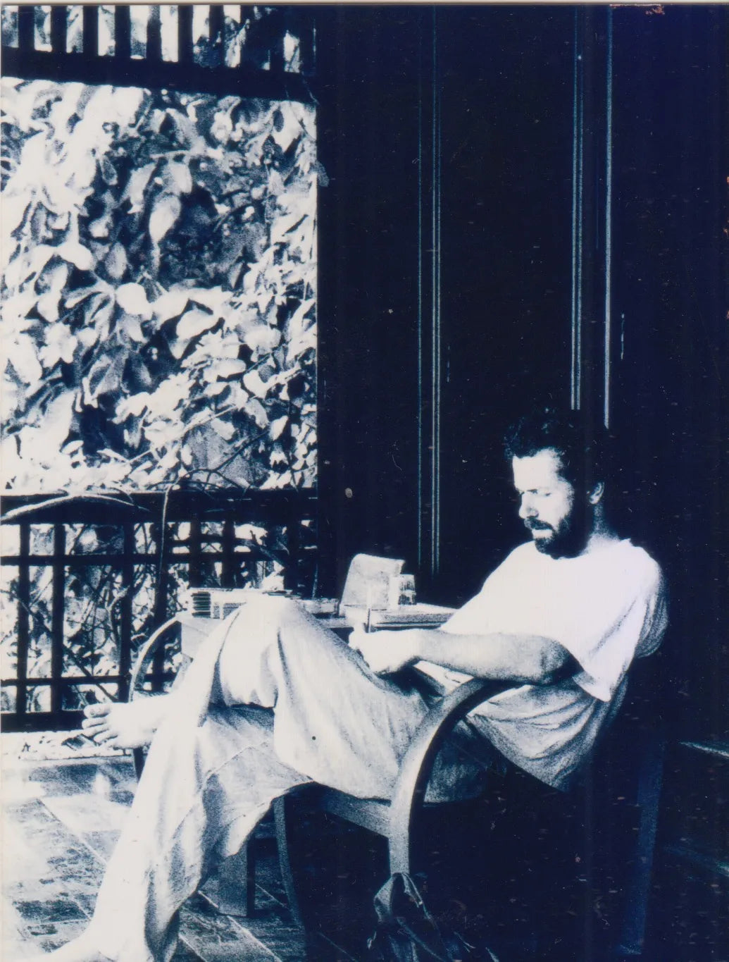 Diego Cortizas reading on a balcony during his travels in Southeast Asia